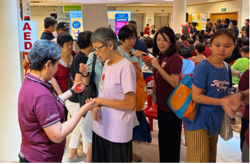 Support group volunteers helping residents at a booth during the event, part of NUHCS's wider push to bring heart health into the community.